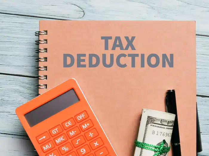 notebook, calculator, pen, and cash: Calculating tax deductions for small business 