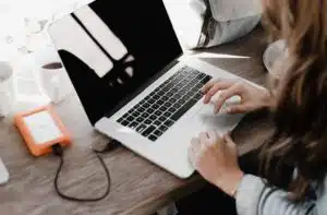 a girl Store Backup on his work on the external hard drive using a laptop