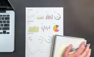 a man performing a interim financial statement using a laptop and a document