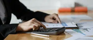 a person doing calculations using a calculator in his desk office
