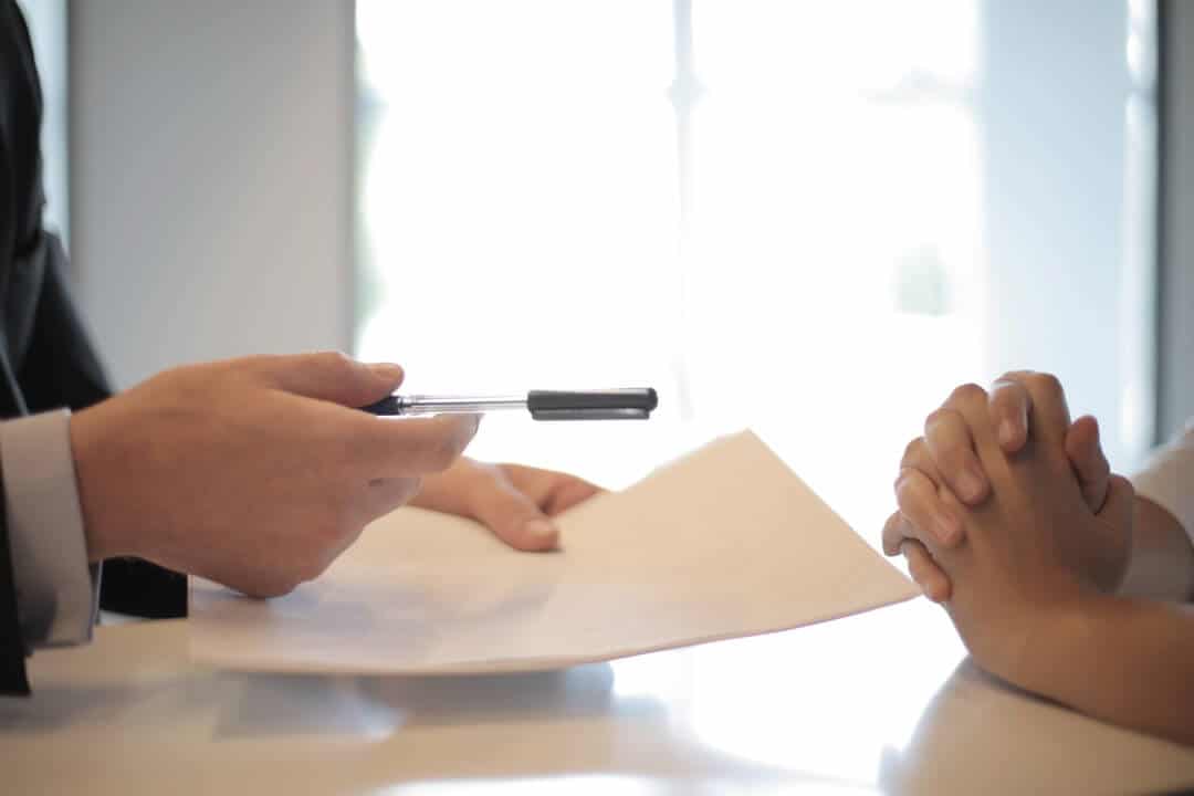 business mans hand holding pen and paper - life insurance